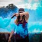Kvinna sprider blå rök från en behållare